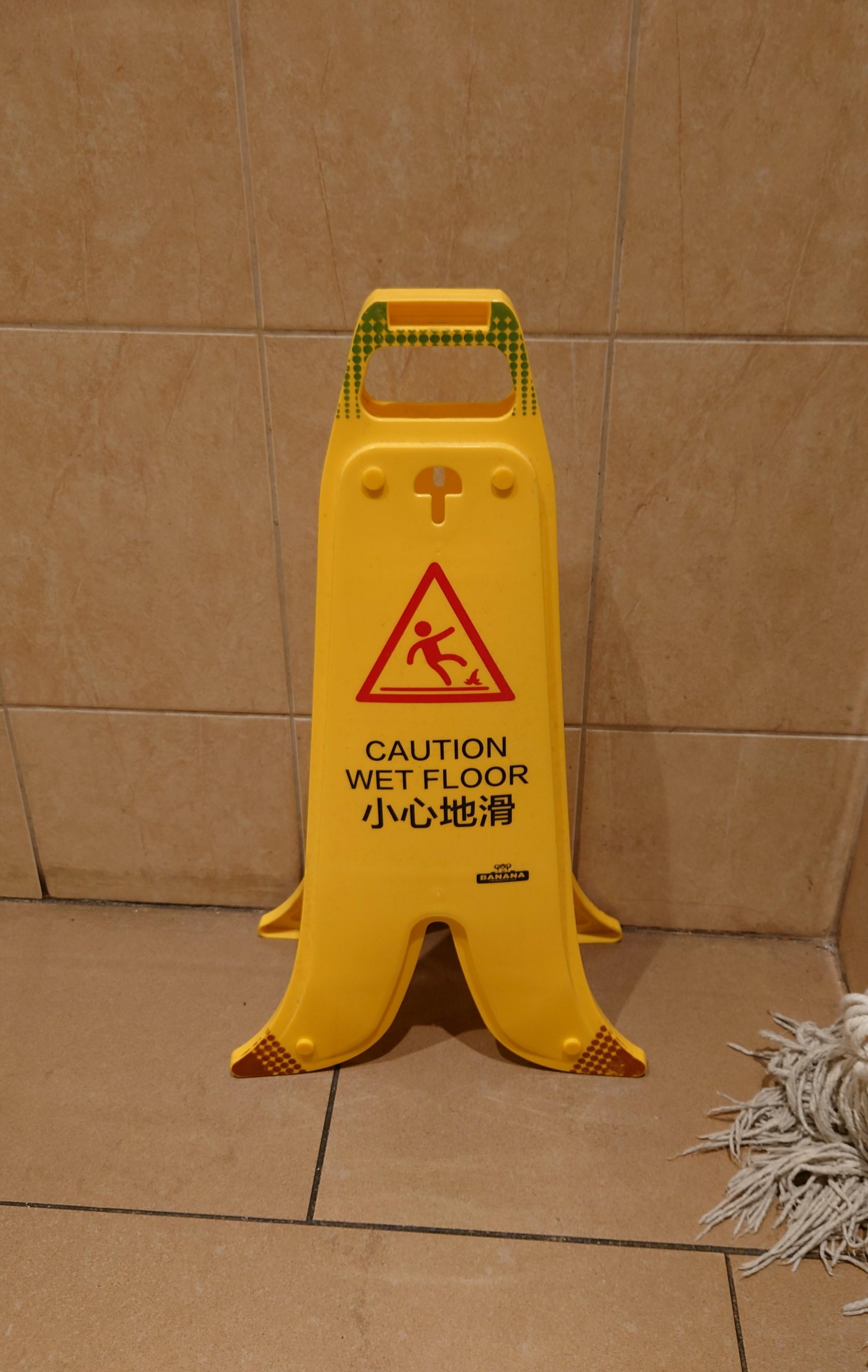 A yellow "caution wet floor" standee. The bottom is flared so it looks like a banana peel.