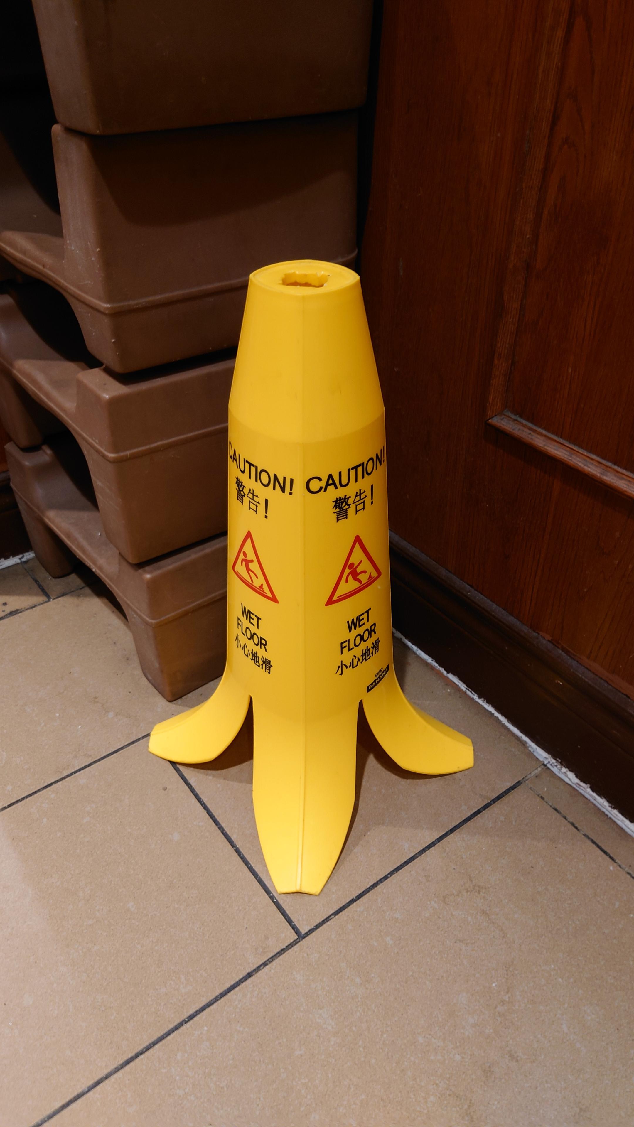 A yellow "caution wet floor" standee. The bottom is flared so it looks like a banana peel.